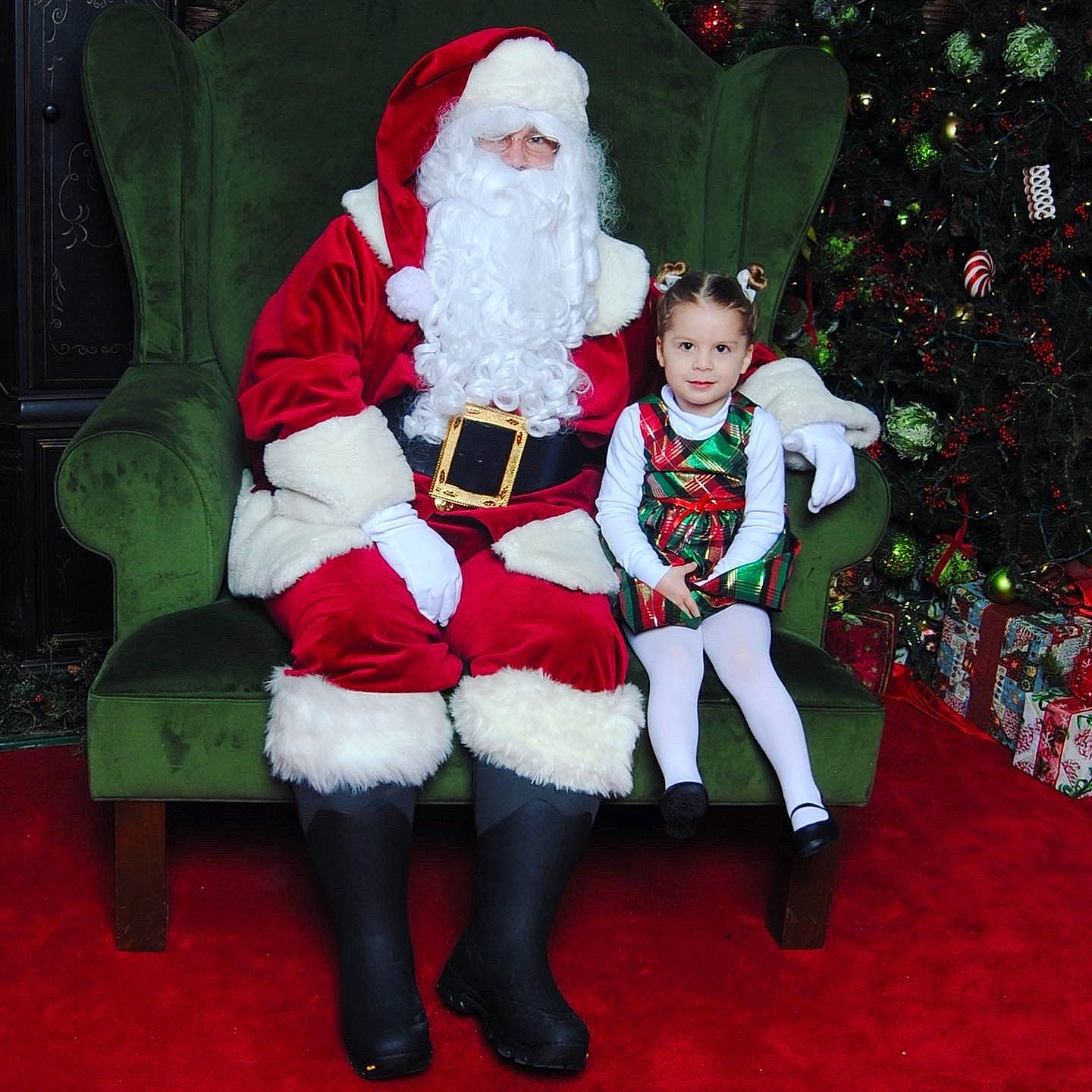 Emily is registered to the contest to win money with this photo: beard, christmas, christmas_decoration, christmas_eve, christmas_tree, costume_hat, event, fictional_character, green, happy, hat, head, holiday, human_body, lap, person, red, santa_claus, sleeve, smile