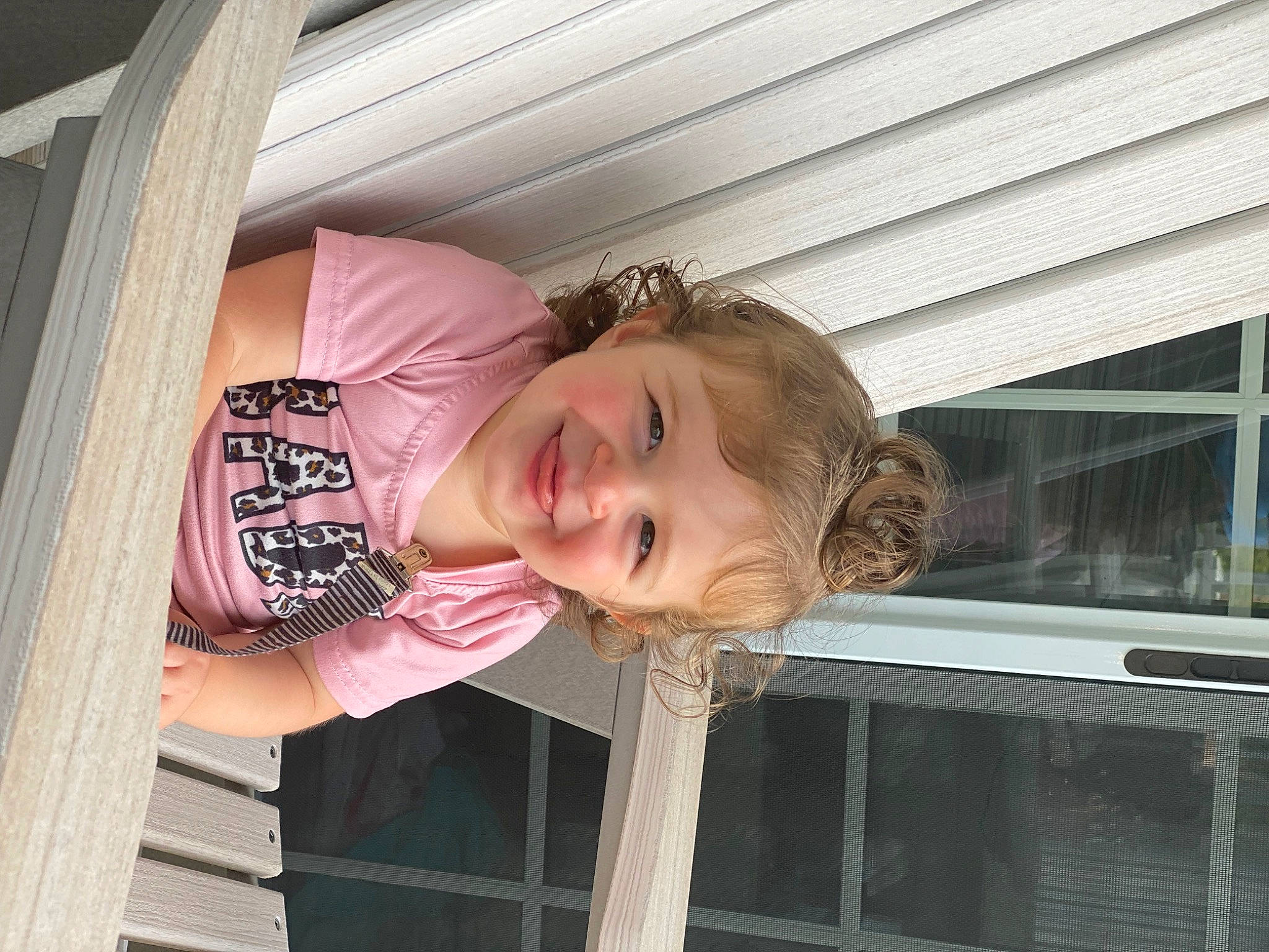 Halston is registered to the contest to win money with this photo: baby_toddler_clothing, blond, building, child, chin, fun, happy, house, joy, leisure, magenta, person, smile, t_shirt, toddler, tree, vacation, window, wood