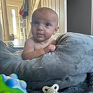 Oakley joined the competition — help win amazing prizes! baby, infant, blue_eyes, blanket, pacifier, toy, indoor, curious, face, skin, hand, soft_texture, floor, home, light, door, stairs, clothing, expression, child