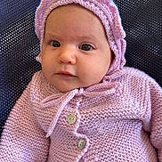 Irina a rejoint le concours — aidez-le/la à gagner de superbes lots ! baby, infant, knitted_clothing, bonnet, purple, cute, face, portrait, child, young, buttoned_sweater, warm_clothing, soft_texture, looking, seated, indoors, closeup, headwear, person, newborn