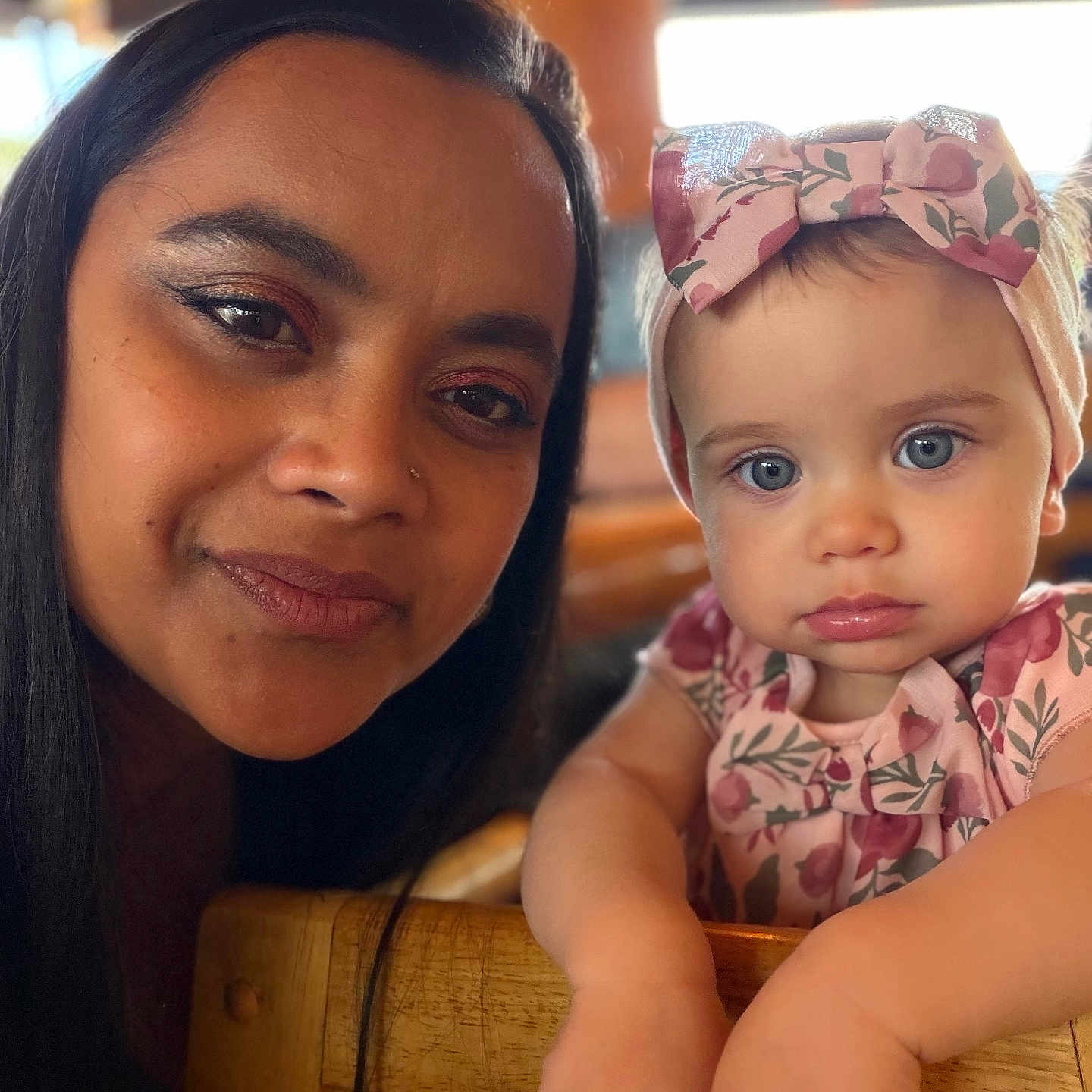 Zaliyah is registered to the contest to win money with this photo: woman, baby, child, face, portrait, headband, blue_eyes, floral_pattern, close_up, indoor, wooden_chair, person, cute, family, mother_and_child, skin, expression, looking_at_camera, casual, love