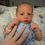 Rowan joined the competition — help win amazing prizes! baby, newborn, infant, face, eyes, hand, adult_hand, manicured_nails, hospital_bracelet, onesie, blanket, bedding, close_up, portrait, indoor, baby_clothing, skin, nursery_item, cute, holding