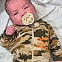 baby, infant, newborn, pacifier, onesie, camouflage, camo_onesie, embroidered_text, blanket, lying_down, face, hand, portrait, indoors, fabric, zipper, cute, sleepy, head, closeup