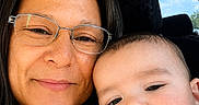 Grayson is registered to the contest to win money with this photo: baby, car_interior, casual_clothing, closeup, daylight, face, family, glasses, happy, head, indoors, mother_and_child, person, portrait, seat, skin, smile, together, window, woman