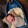 Elizah is registered to the contest to win money with this photo: newborn, baby, yawn, wrap, pillow, basket, blue, wooden_floor, cozy, soft, blanket, infant, sleepy, cute, indoor, portrait, child, knitwear, resting, lying_down
