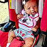 baby, infant, child, car_seat, sitting, portrait, smiling, bow, bib, disney, strawberries, striped_clothing, red, pink, white, harness, seat_belt, outdoor, vehicle, safe