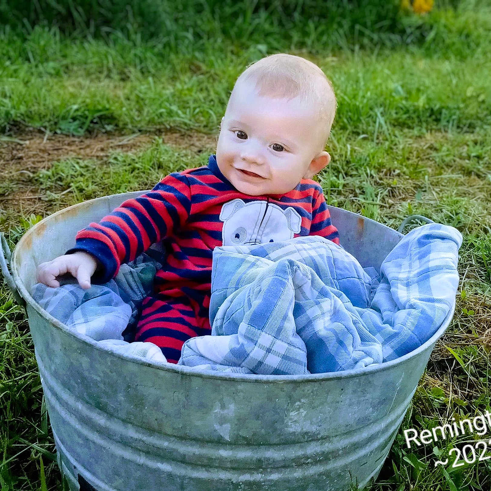 Remington is registered to the contest to win money with this photo: baby, backyard, bathing, bathtub, blanket, bucket, clothing, face, grass, head, nature, outdoors, person, photography, plant, portrait, pottedplant, sitting, tub, yard