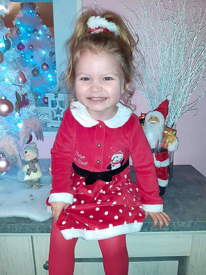 Diana participe au concours pour gagner de l'argent avec cette photo : baby_toddler_clothing, blue, christmas_tree, face, facial_expression, fun, green, happy, head, human_body, joy, organ, people, person, pink, red, sleeve, smile, standing, textile