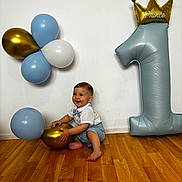Lawson a rejoint le concours — aidez-le/la à gagner de superbes lots ! baby, boy, balloons, birthday, number_one, party, floor, wooden_floor, smiling, happy, indoor, white_wall, gold_balloon, blue_balloon, white_balloon, clothing, bow_tie, crown, celebration, child