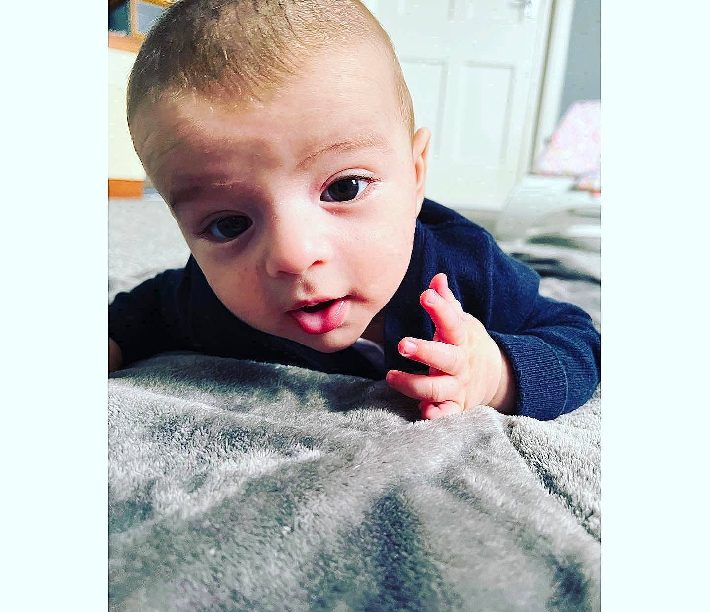 Petru is registered to the contest to win money with this photo: arm, baby, baby_toddler_clothing, cheek, chin, comfort, eyelash, flash_photography, flooring, gesture, hair, happy, iris, linens, mouth, neck, nose, person, skin, sleeve