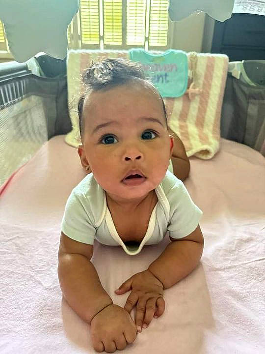 Milani Love is registered to the contest to win money with this photo: baby, baby_toddler_clothing, cheek, child, comfort, dress, eye, eyebrow, eyelash, floor, flooring, fun, hairstyle, happy, head, iris, nose, person, skin, smile