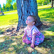 Rahaf joined the competition — help win amazing prizes! child, toddler, tree, grass, park, outdoor, sunlight, dress, pink, plaid, sitting, curious, nature, daytime, people, bench, shadows, greenery, young_child, earrings