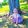 child, toddler, tree, grass, park, outdoor, sunlight, dress, pink, plaid, sitting, curious, nature, daytime, people, bench, shadows, greenery, young_child, earrings