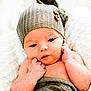 baby, infant, newborn, hat, knitted_hat, blanket, wrapped, soft_texture, white_background, cute, face, hands, skin, closeup, portrait, resting, expression, cozy, warm, indoor