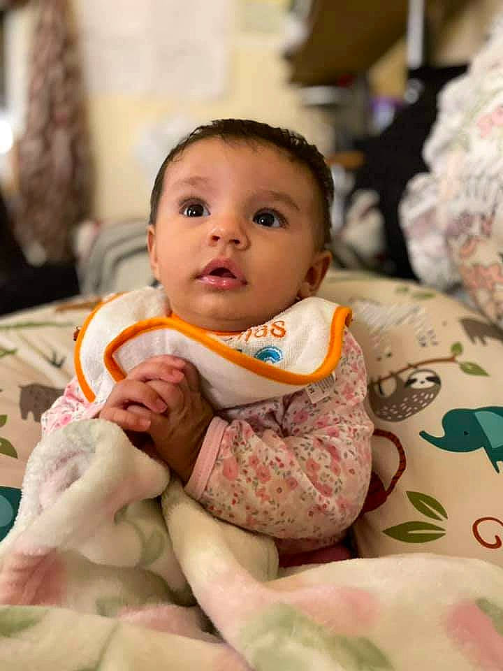 Amber is registered to the contest to win money with this photo: baby, baby_toddler_clothing, bib, chair, cheek, child, comfort, event, eye, face, fun, happy, head, human_body, linens, neck, person, room, sitting, skin