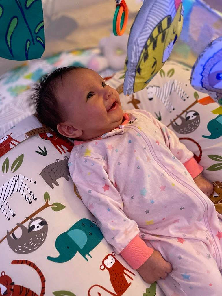 Amber is registered to the contest to win money with this photo: baby, baby_products, baby_toddler_clothing, bedding, cheek, child, comfort, fun, green, happy, linens, pattern, person, photograph, pink, skin, sleeve, smile, textile, toddler