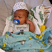 August joined the competition — help win amazing prizes! baby, infant, pacifier, blanket, hat, clothing, baby_seat, cushion, face, person, sleepwear, blue_blanket, striped_shirt, indoor, cute, newborn, adorable, comfort, resting, young_child