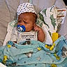 baby, infant, pacifier, blanket, hat, clothing, baby_seat, cushion, face, person, sleepwear, blue_blanket, striped_shirt, indoor, cute, newborn, adorable, comfort, resting, young_child