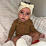 Gracie is registered to the contest to win money with this photo: baby, infant, headband, bow, leopard_print, clothing, sitting, blanket, white, red_shoes, footwear, cute, portrait, indoors, child, person, face, expression, soft_texture, cozy