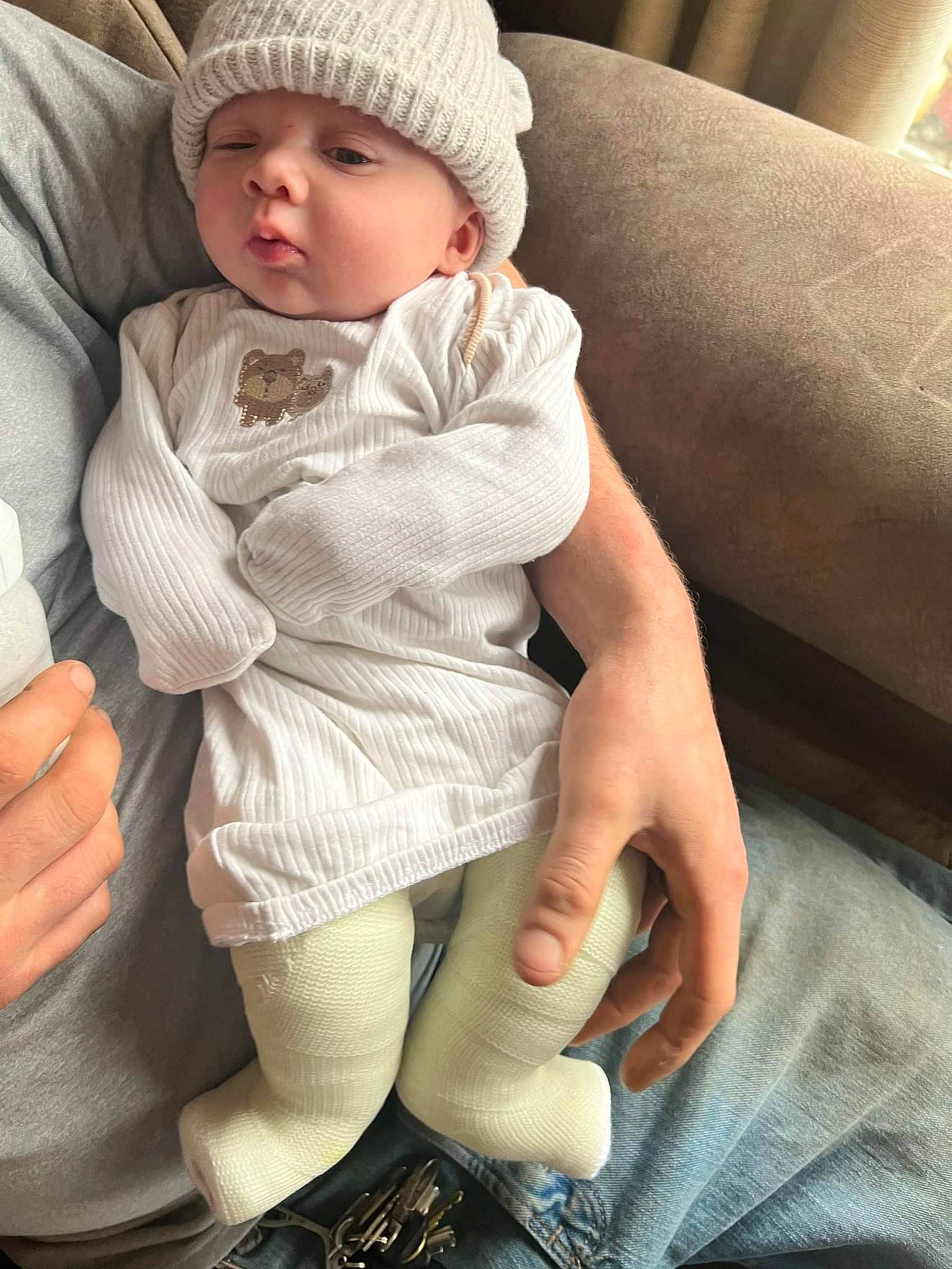 Mikah is registered to the contest to win money with this photo: baby, baby_toddler_clothing, cap, cheek, comfort, eye, face, finger, gesture, hand, head, headwear, knee, lap, leg, lip, person, skin, sleeve, thigh