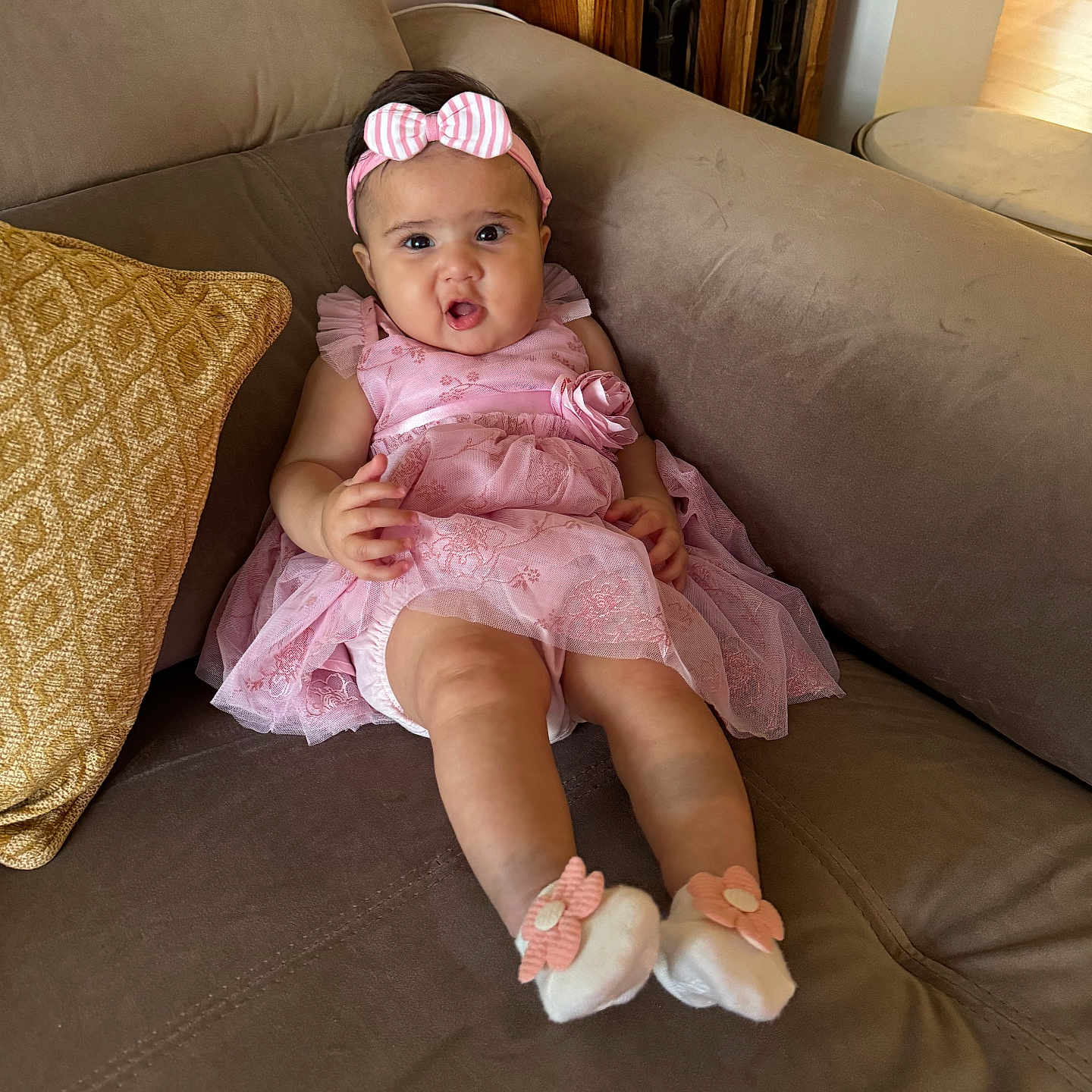 Siara joined the competition — help win amazing prizes! baby, child, couch, cute, expression, flower, furniture, happy, headband, home, indoor, infant, legs, person, pillow, pink_dress, portrait, seated, socks, young