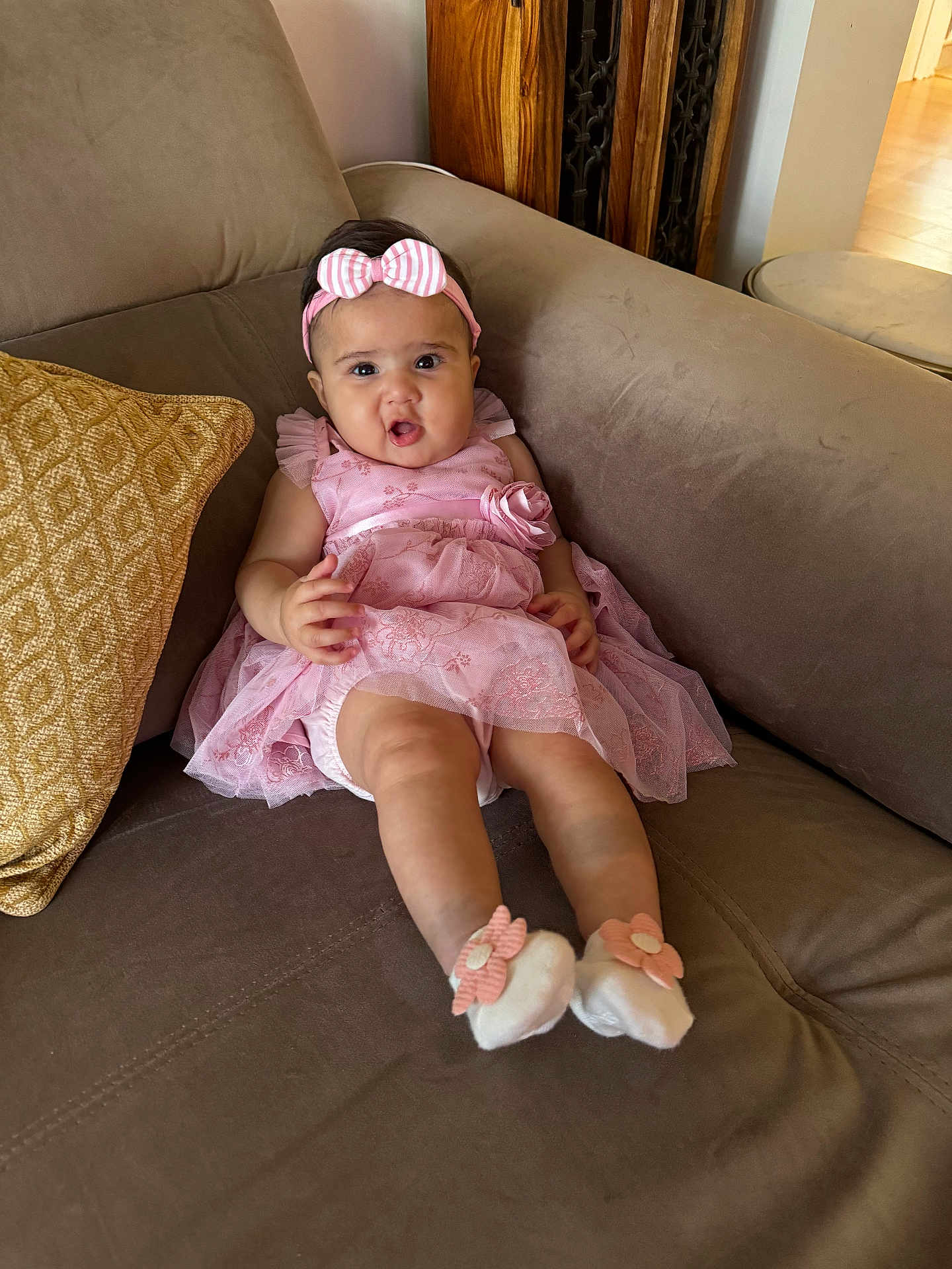 Siara joined the competition — help win amazing prizes! baby, child, infant, pink_dress, headband, couch, pillow, socks, flower, indoor, furniture, person, cute, portrait, happy, young, seated, home, expression, legs