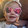 baby, sunglasses, reflection, headband, car_seat, smile, drool, child, seatbelt, white_clothing, face, closeup, sunlight, happy, portrait, infant, cute, accessory, person, outdoor_reflection