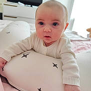 Anna a rejoint le concours — aidez-le/la à gagner de superbes lots ! baby, infant, child, face, eyes, pillow, star_pattern, blanket, bed, bedding, bedroom, dresser, television, onesie, white_clothing, portrait, close_up, cute, hand, stuffed_animal