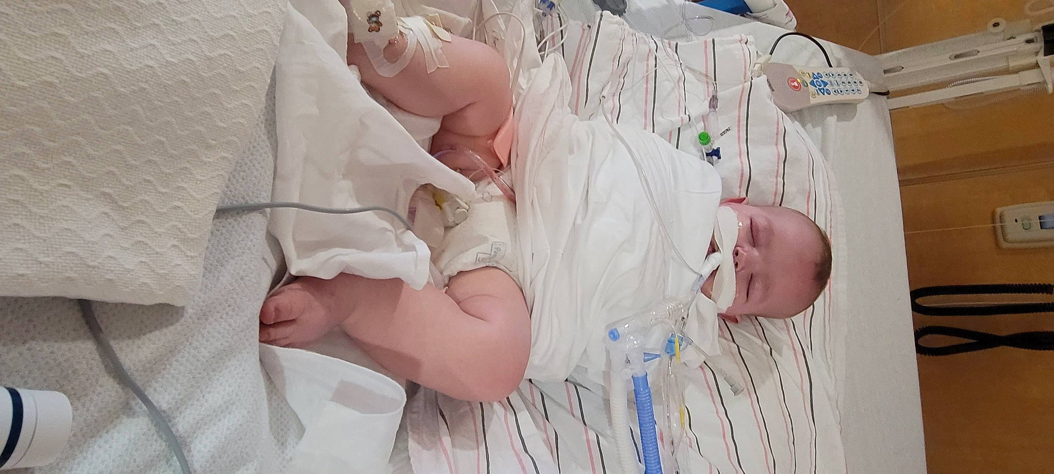 Christopher is registered to the contest to win money with this photo: abdomen, baby, baby_toddler_clothing, child, childbirth, comfort, event, finger, foot, gesture, hat, hospital, linens, person, room, service, skin, textile, thumb, toddler