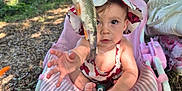 Livina a rejoint le concours — aidez-le/la à gagner de superbes lots ! child, toddler, baby, fish, outdoor, nature, hat, baby_seat, summer, curious, reaching_hand, grass, leaves, sunlight, path, pink, flora_pattern, forest, young_child, playful