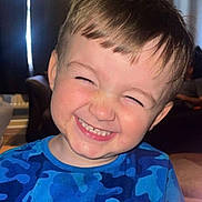 Xander joined the competition — help win amazing prizes! child, boy, smiling, face, blue_shirt, indoor, curtains, hair, happy, portrait, teeth, candid, cute, light, camouflage, person, expression, sitting, room, joyful