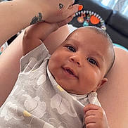Jrue joined the competition — help win amazing prizes! baby, infant, smiling, hand, tattoo, nail_polish, onesie, elephant_pattern, person, legs, living_room, couch, curtains, skin, happy, closeup, indoor, holding_hand, cute, portrait