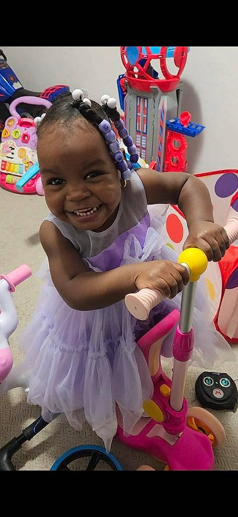 Nia is registered to the contest to win money with this photo: child, costume, entertainment, event, fun, happy, joy, laugh, leisure, magenta, party, party_supply, performing_arts, person, pink, play, purple, recreation, smile, tire