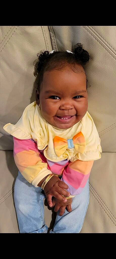 Nia is registered to the contest to win money with this photo: baby, baby_toddler_clothing, cheek, eye, finger, gesture, hair, happy, head, iris, joy, lip, mouth, neck, nose, person, pink, product, skin, sleeve