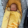 Mathis participe au concours pour gagner de l'argent avec cette photo : baby, newborn, sleeping, blanket, yellow, orange, striped, cushion, star_pattern, carrier, infant, cozy, wrapped, peaceful, small, cute, soft, resting, child, indoors