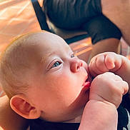 Mathis participe au concours pour gagner de l'argent avec cette photo : baby, child, close_up, face, hands, blue_eyes, skin, indoor, natural_light, person, sitting, fingers, cute, portrait, infant, chubby_cheeks, soft_light, black_clothing, background, blurred