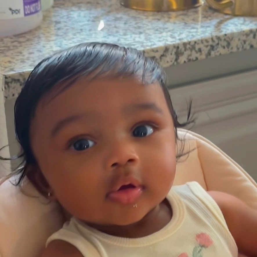 Amira joined the competition — help win amazing prizes! baby, ballet_shoes, child, clothing, counter, cushion, cute, eyes, face, flower, gold, hair, indoors, infant, kitchen, pink, portrait, seat, sleeveless_top, watering_can