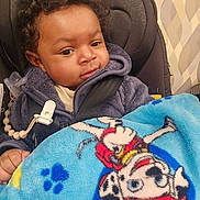 Avery joined the competition — help win amazing prizes! baby, child, car_seat, blanket, blue_blanket, cartoon_character, paw_prints, clothing, fleece_jacket, curly_hair, indoor, infant, person, seatbelt, safety, cute, portrait, hand, comfort, young_child