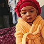 Avery joined the competition — help win amazing prizes! baby, child, robe, bonnet, socks, bed, blanket, purple, yellow, indoor, cute, face, person, clothing, headwear, expression, infant, sitting, warm, cozy