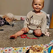 Mayrilda is registered to the contest to win money with this photo: blanket, cake, carpet, child, cute, diaper, floor, food, furniture, happy, indoor, messy, person, playtime, red_ribbon, smile, snack, sweater, toddler, toy