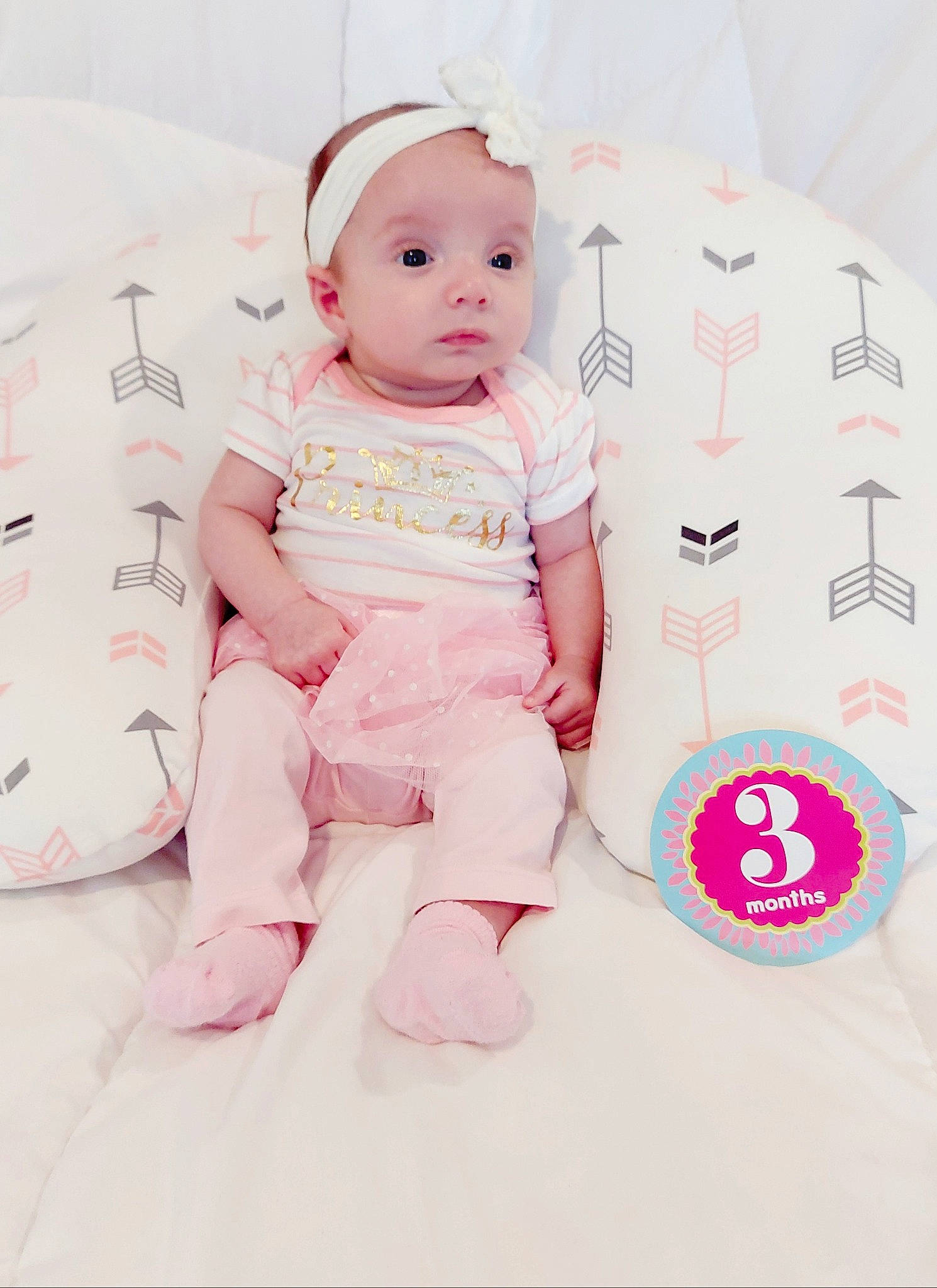 Avalee is registered to the contest to win money with this photo: baby, baby_products, baby_toddler_clothing, carmine, cheek, child, comfort, facial_expression, foot, happy, headwear, linens, magenta, pattern, peach, person, pink, room, sitting, sleeve