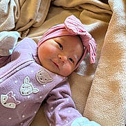 Ily joined the competition — help win amazing prizes! baby, infant, pink_headband, purple_onesie, animal_patches, blanket, soft_texture, gloves, cute, smiling, face, closeup, newborn, cozy, warm, indoor, child, portrait, sleepwear, resting