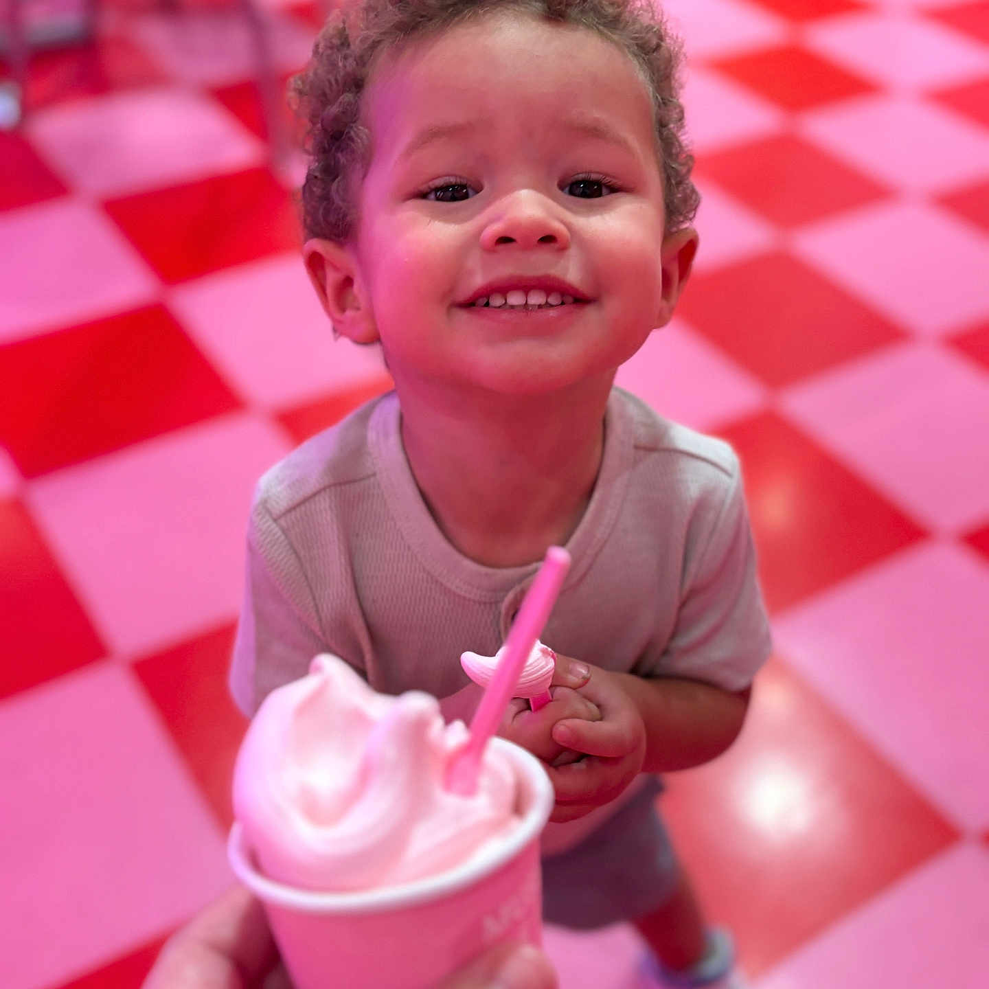 Dashane joined the competition — help win amazing prizes! checkered_floor, child, closeup, clothing, cup, curly_hair, dessert, floor, food, hand, happy, ice_cream, indoor, person, pink, pink_floor, red, shoes, smiling, toddler