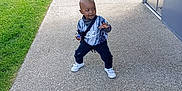 Assaf a rejoint le concours — aidez-le/la à gagner de superbes lots ! toddler, child, outdoor, concrete, grass, toy, sneakers, black_pants, shirt, playful, pose, daylight, metal_structure, sidewalk, greenery, young_child, standing, casual_clothing, nature, happy