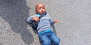 Assaf a rejoint le concours — aidez-le/la à gagner de superbes lots ! asphalt, bag, boy, casual, child, clothing, curious, daylight, expression, footwear, jeans, laying_down, outdoor, shadow, small_bag, sneakers, street, sweater, urban, young