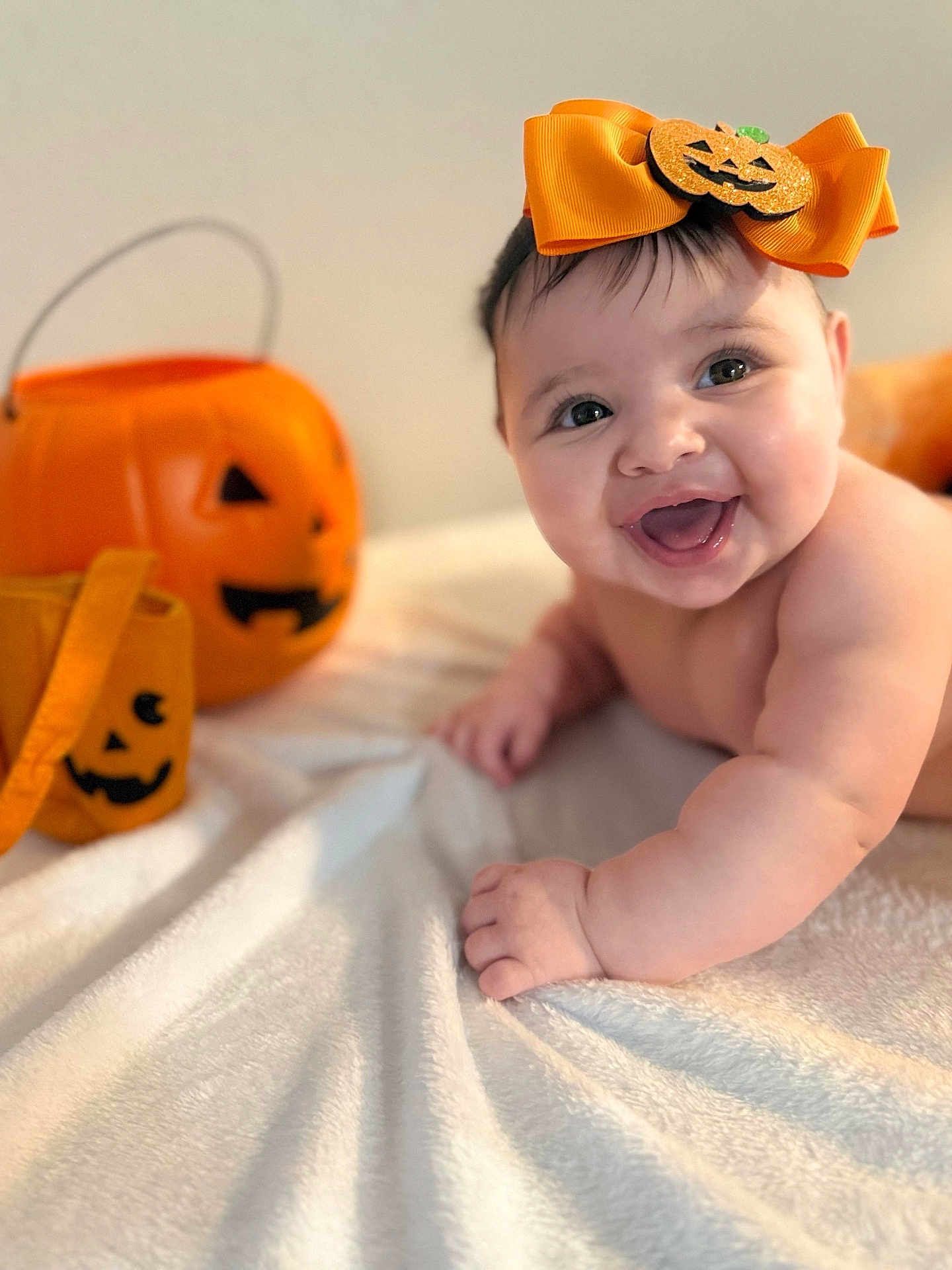 Salomé Santos joined the competition — help win amazing prizes! baby, smiling, orange_bow, pumpkin, halloween, blanket, cute, infant, happy, face, portrait, child, holiday, decor, costume_accessory, indoor, celebration, cute_expression, joy, festive