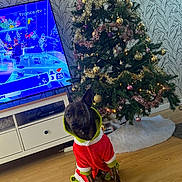 Marley a rejoint le concours — aidez-le/la à gagner de superbes lots ! dog, christmas_tree, holiday_outfit, gift, wrapped_present, wooden_floor, television, decorations, ornaments, tinsel, lights, furniture, living_room, pet, indoors, festive, costume, cute, animal, background