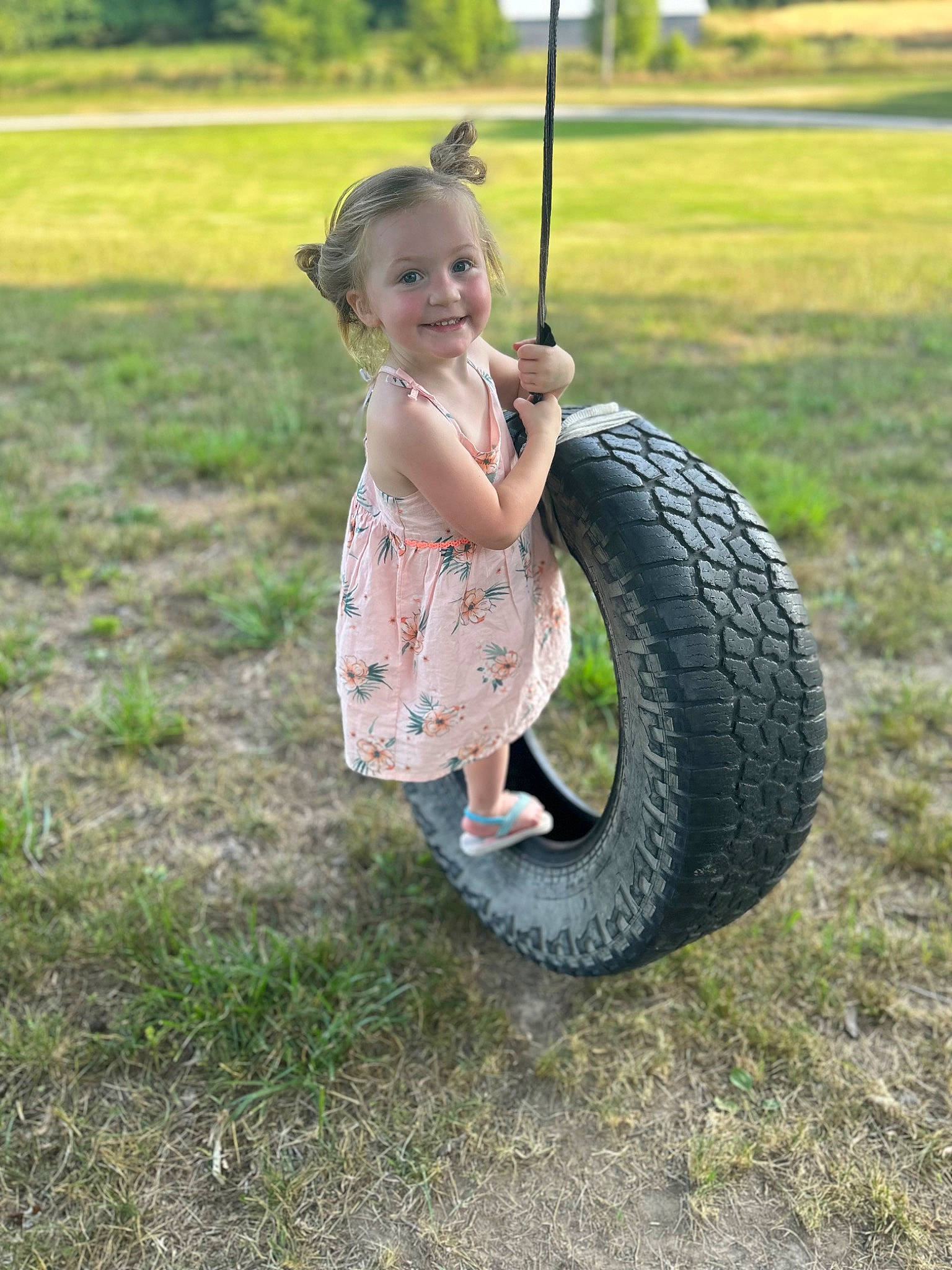 Kinzley is registered to the contest to win money with this photo: automotive_tire, automotive_wheel_system, baby_toddler_clothing, bicycle_tire, fun, grass, grassland, happy, joy, lawn, leisure, people_in_nature, person, rim, smile, swing, synthetic_rubber, tire, tire_care, toddler