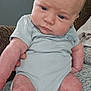 Curtis joined the competition — help win amazing prizes! baby, infant, child, onesie, blue_clothing, sitting, blanket, patterned_blanket, indoor, face, skin, expression, serious, hand, leg, person, young_child, head, hair, closeup