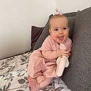 Magdalena participe au concours pour gagner de l'argent avec cette photo : baby, bed, blanket, blue_eyes, child, cozy, cushion, cute, feet, hair_bow, happy, home, indoor, infant, person, pink_dress, plush_toy, portrait, sitting, smiling